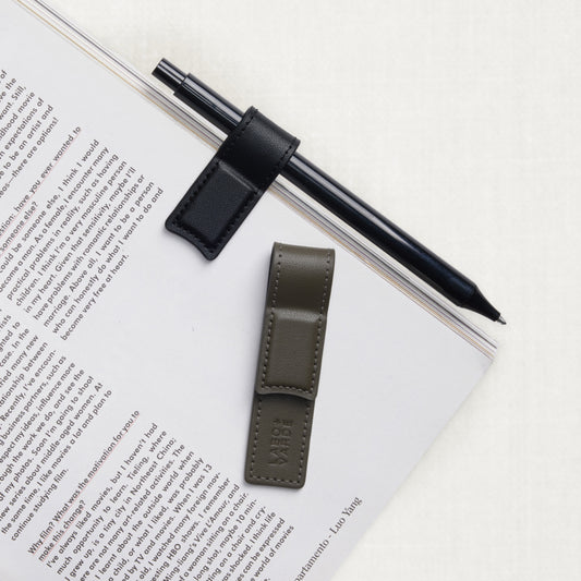 Labovarde Book Clips in Black and Etoupe — Flat lay view on an open book page with a black pen