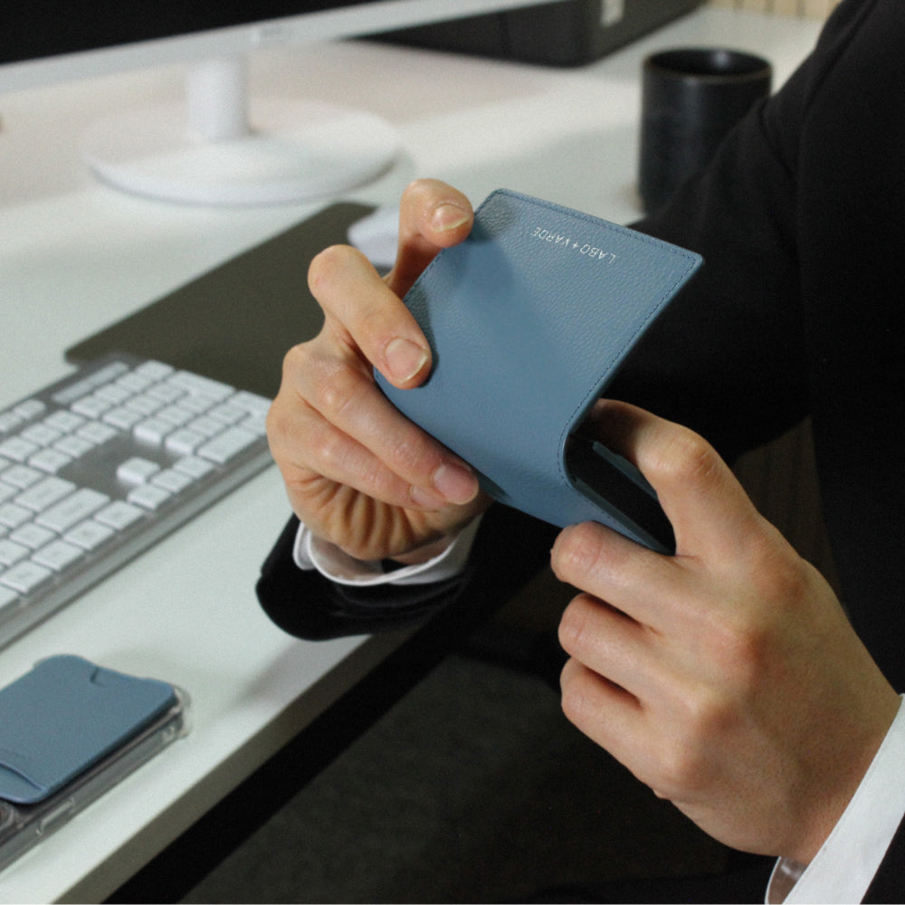 Labovarde Business Card Holder in Pale Blue — Close-up view of hands holding the case open at a modern office desk