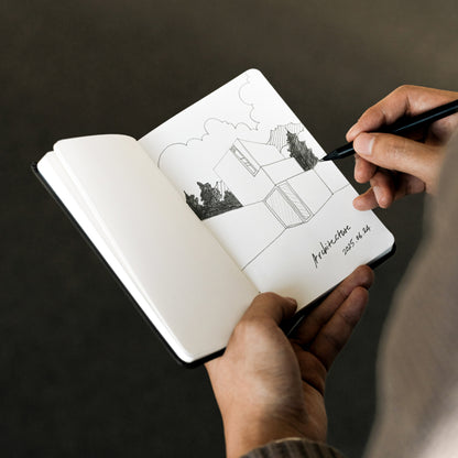 Labovarde Handy Note in Black — Close-up view of hands sketching an architectural drawing in the open note