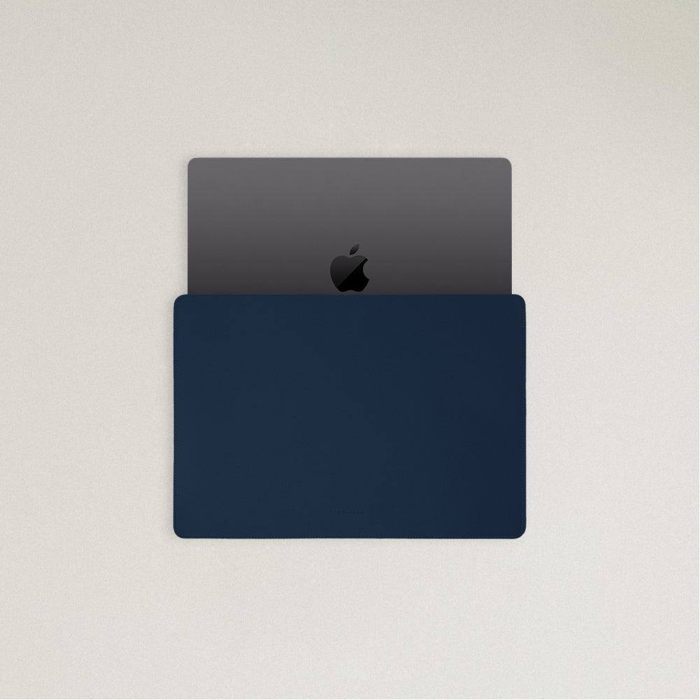 Labovarde Laptop Sleeve in Navy — Top view with a space gray MacBook partially inserted to show the sleek fit